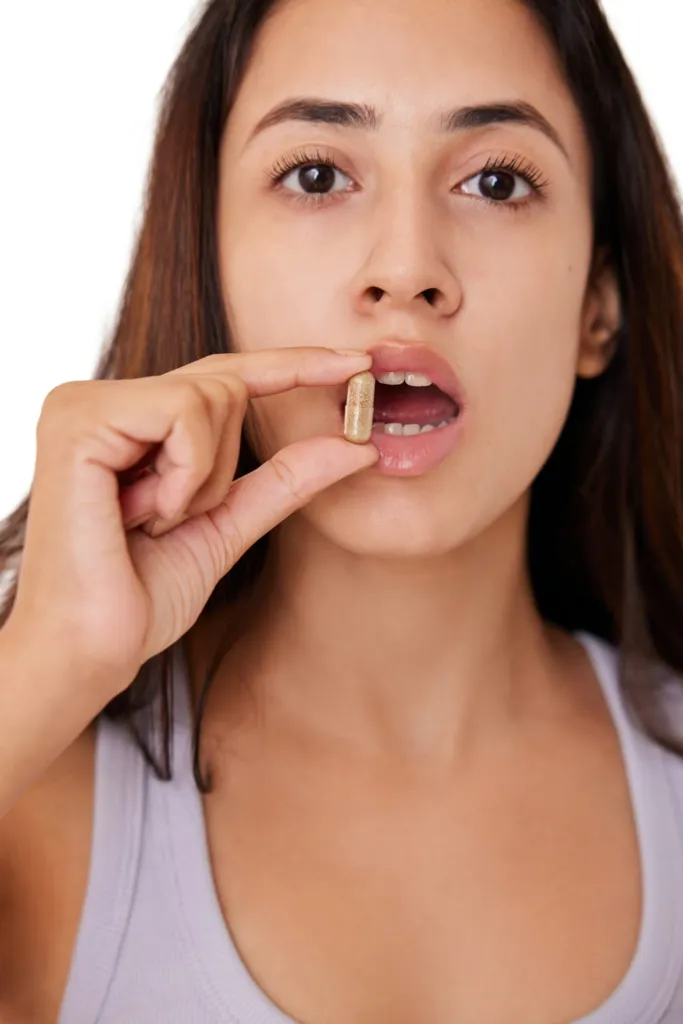 Woman taking a daily supplement capsule